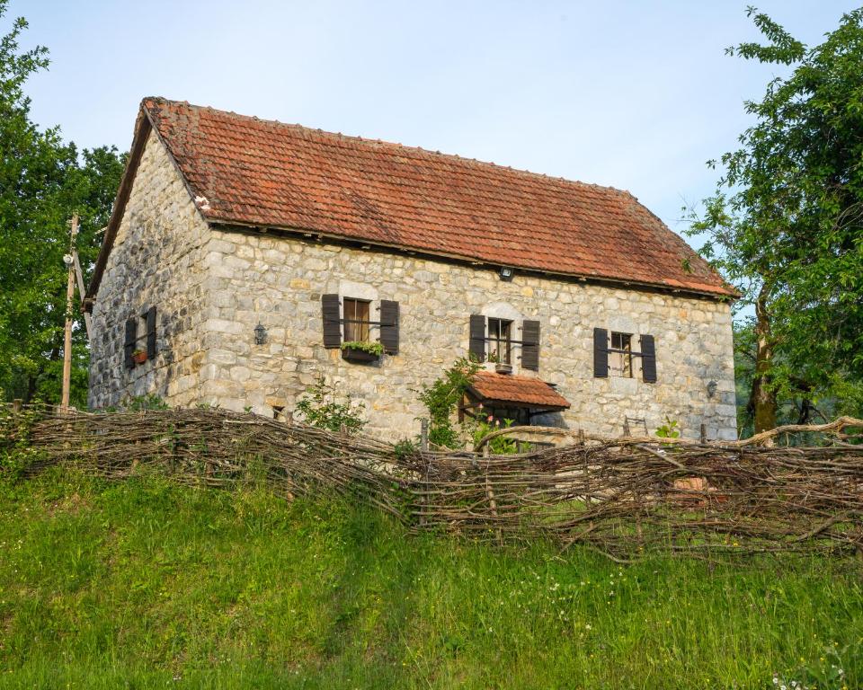 科拉欣Djurdjevina Family Farm的一座老石屋,坐落在草地山丘上