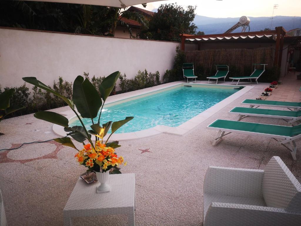 丰达切洛Villa Grazia的一个带椅子和花瓶的游泳池