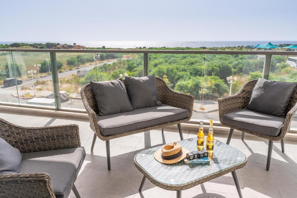 纳哈里亚Stunning 4-bedroom Apartment Next to Achziv Beach by Sea N' Rent的阳台配有椅子和桌子,并提供饮料