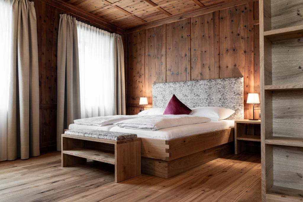 布列瑟农Garni Hotel Tauber的一间卧室设有一张床和木墙