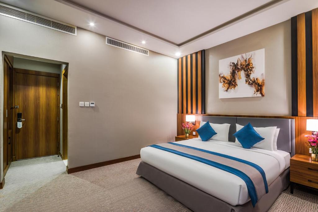 利雅德Myrtle Hotel - Al Sahafa的一间卧室配有一张带蓝色枕头的大床