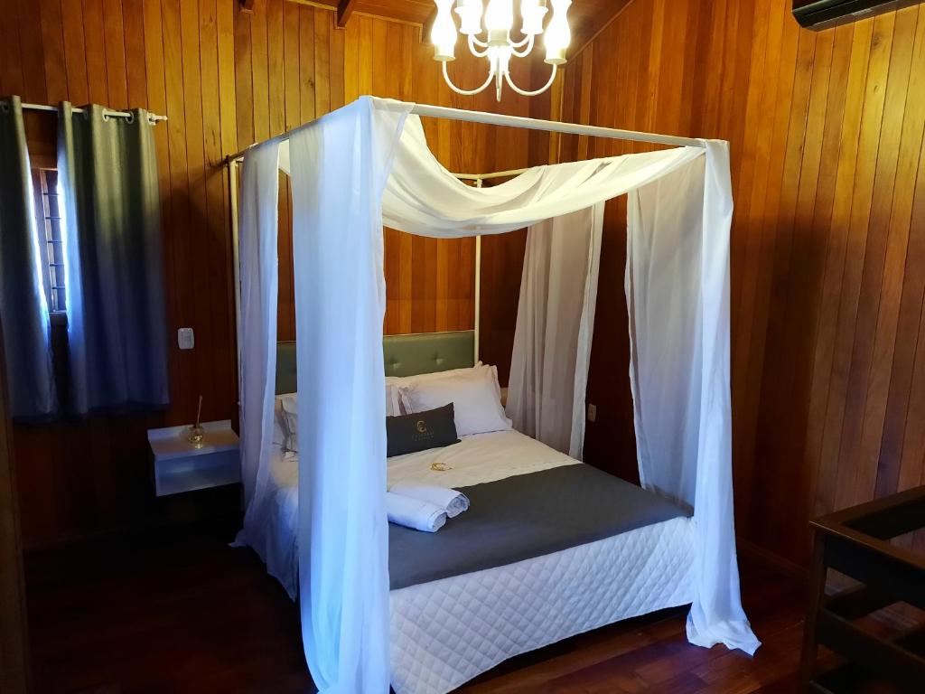 卡内拉Pousada Catedral的一间卧室配有一张带天蓬的床