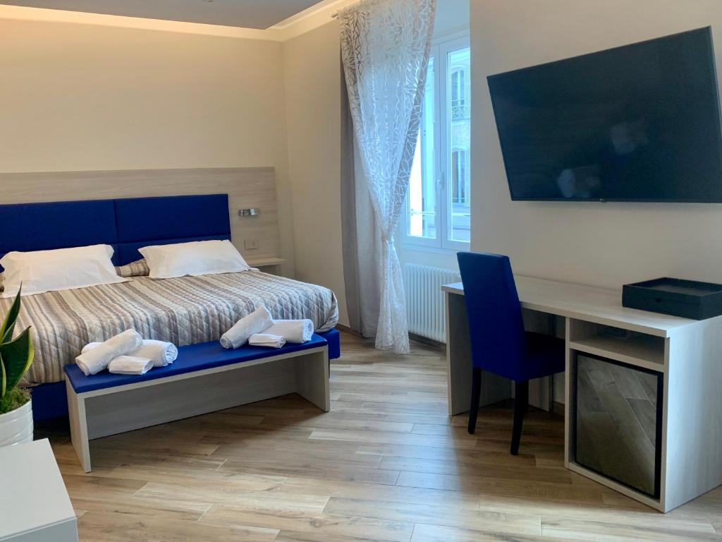 圣雷莫A Due Passi - Sanremo Apartments的一间卧室配有一张床和一张带电脑的书桌
