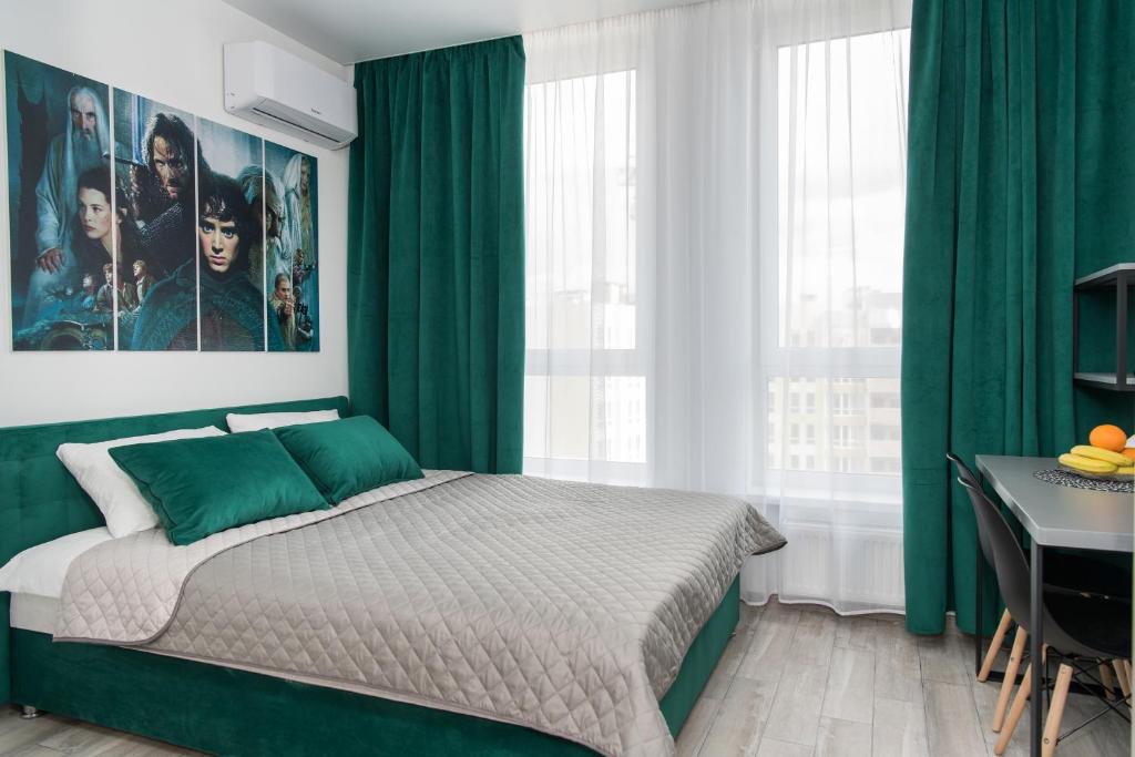 基辅MYFREEDOM Апартаменти метро Нивки的一间卧室配有绿色窗帘、一张床和一张书桌