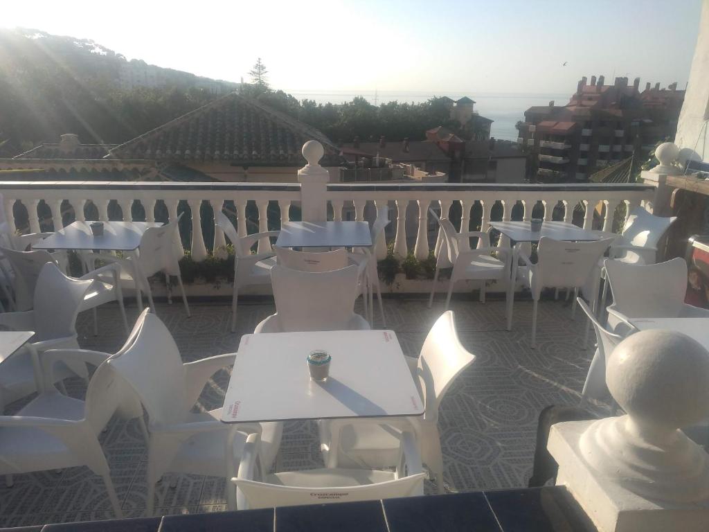 马拉加Terraza del Limonar的阳台的庭院配有白色的桌椅