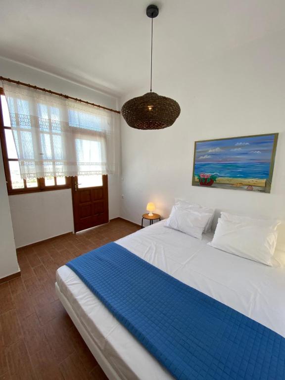 GalanádhonAgrabely的一间卧室配有一张大白色床和蓝色毯子