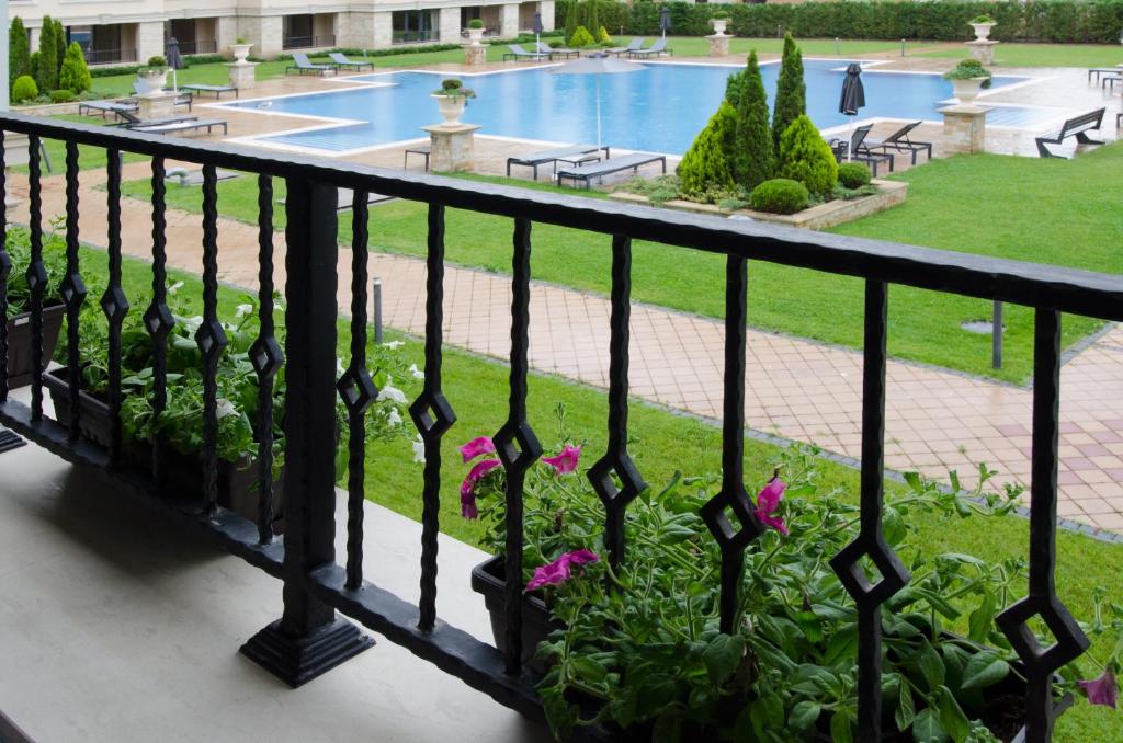 圣君士坦丁和海伦那Апартамент Молинезия的享有游泳池和鲜花景致的阳台