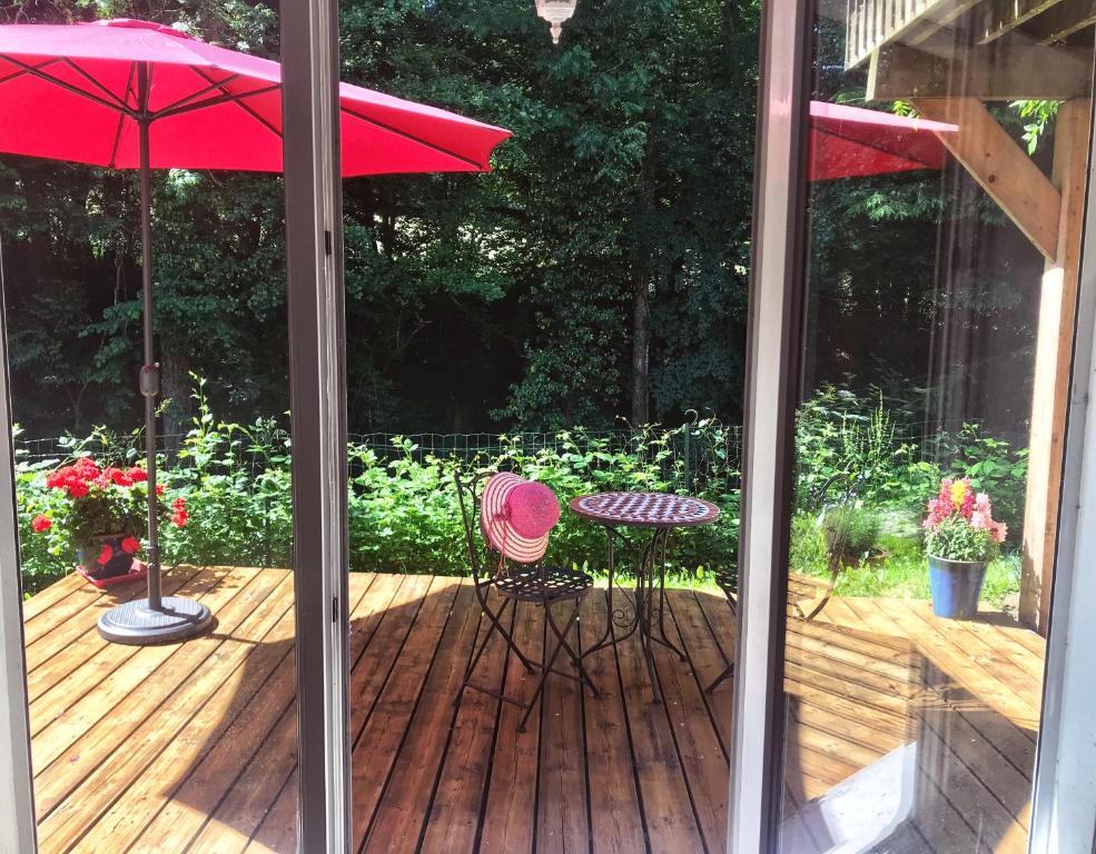 维伊勒佩Appartement au calme avec terrasse verdoyante entre Annecy et Genève的庭院配有桌椅和遮阳伞。