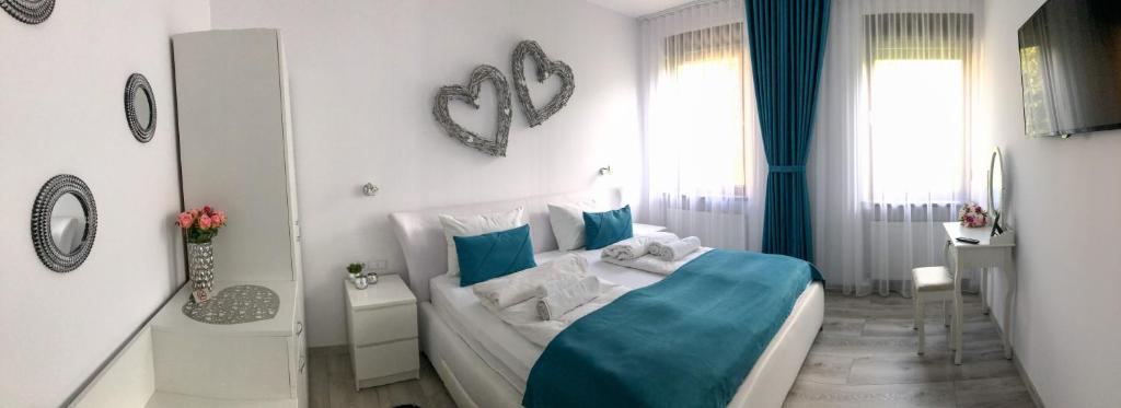 锡比乌Gizell Apartment 1的一间带蓝色和白色床的卧室以及一间浴室。