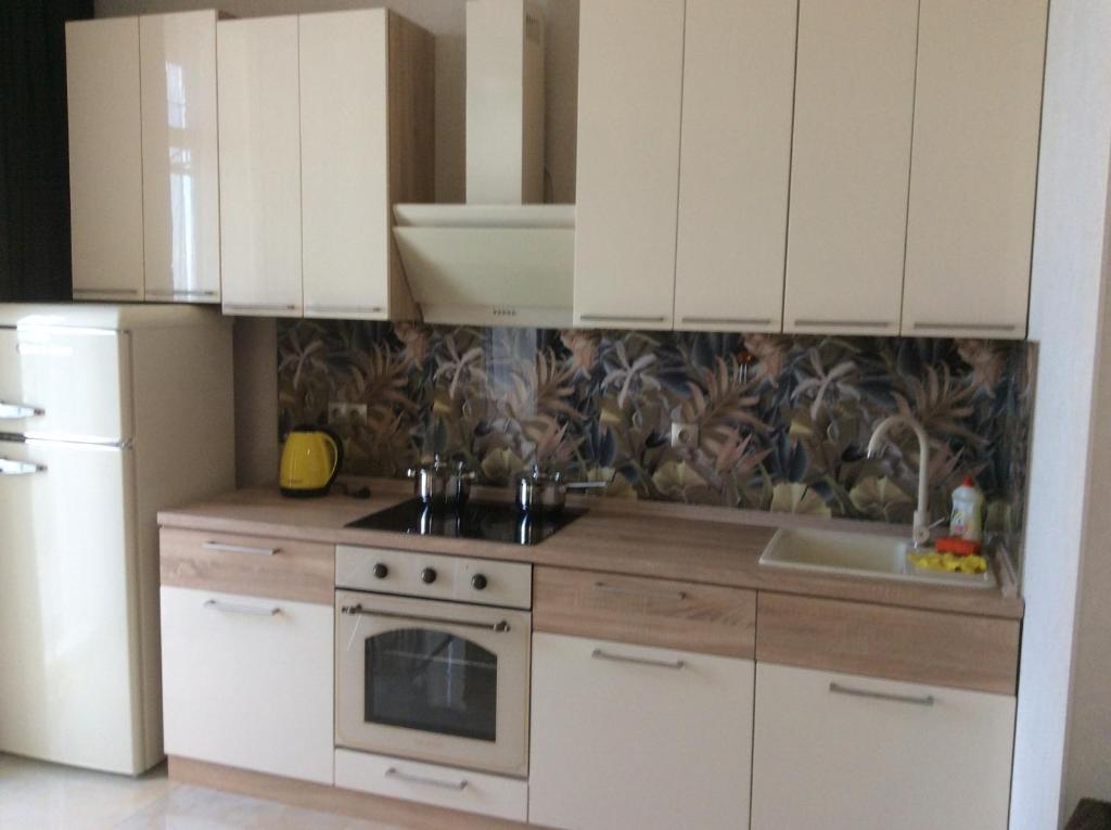 敖德萨Сдам квартиру у моря Элегия парк Аркадия的厨房配有白色橱柜和炉灶烤箱。
