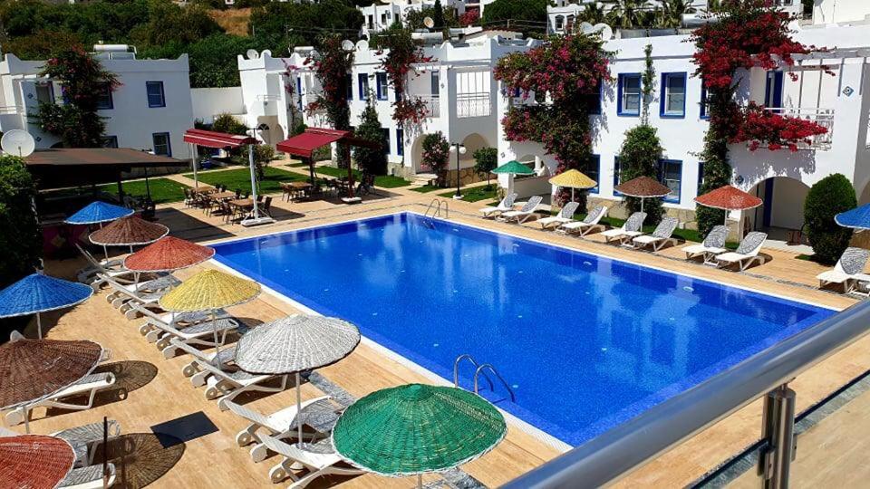 居姆贝特天堂公寓酒店 的一个带椅子和遮阳伞的室外游泳池