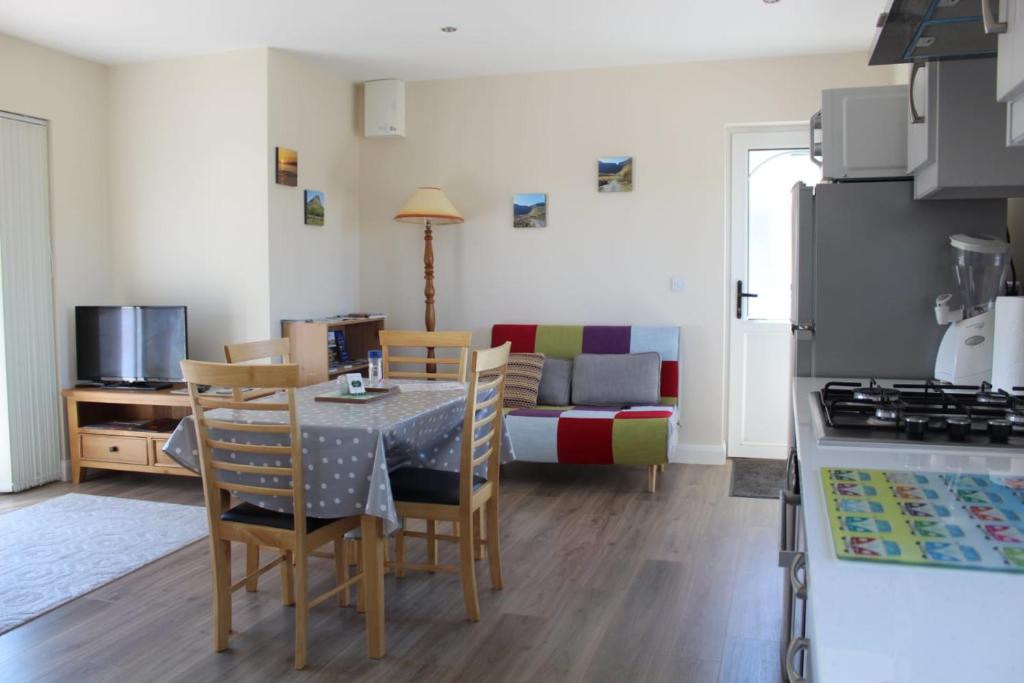 BallaghnatrillickBen Haven Self Catering Accommodation的厨房以及带桌椅的起居室。