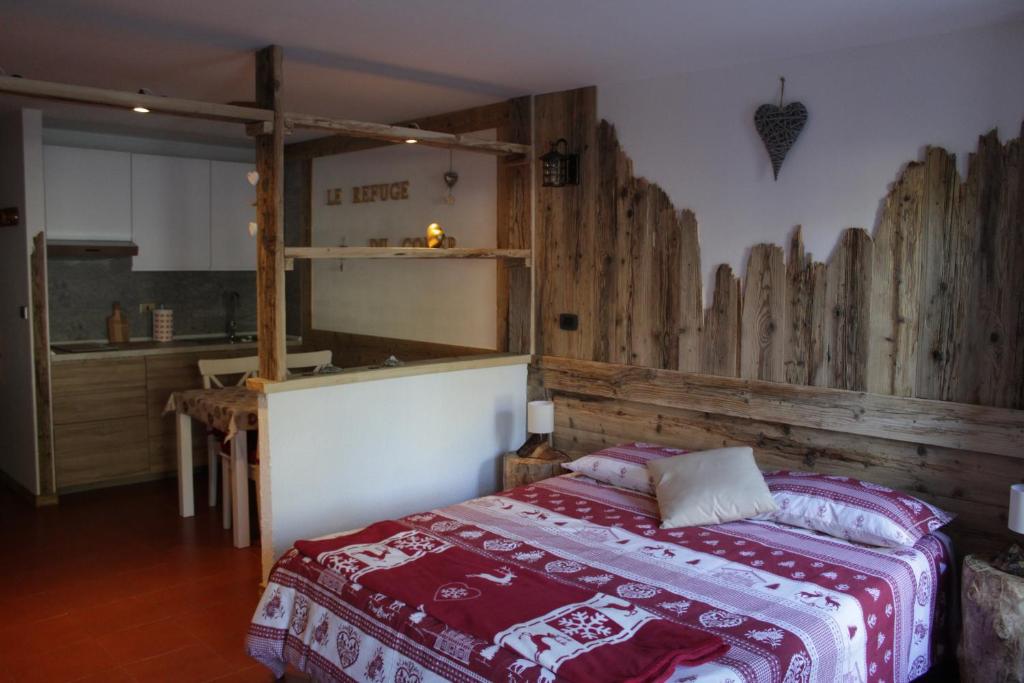 普雷圣迪迪埃LE REFUGE DU COEUR的一间卧室设有一张床和木墙