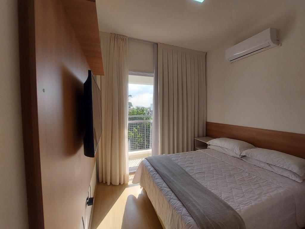 科蒂亚Flat Completo的一间卧室设有一张床和一个大窗户