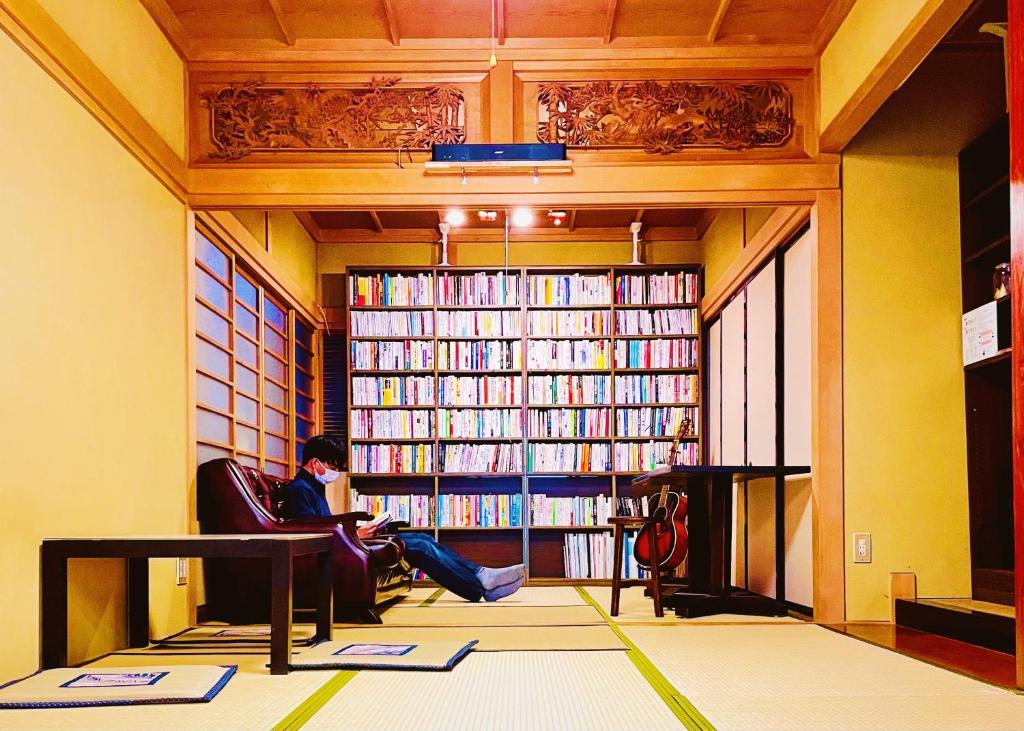 富山泊まれる図書館 寄処 -yosuga-的坐在图书馆前椅子上的女人