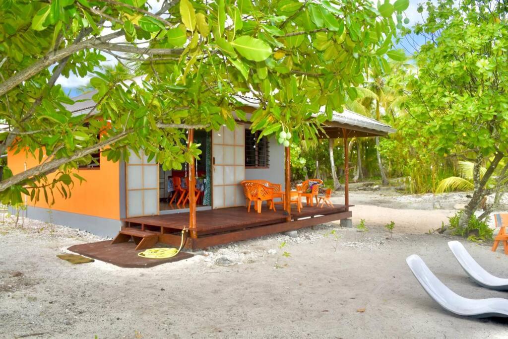 提克豪Hiti Tikehau, the ocean side bungalow的一座小房子前面设有门廊和椅子