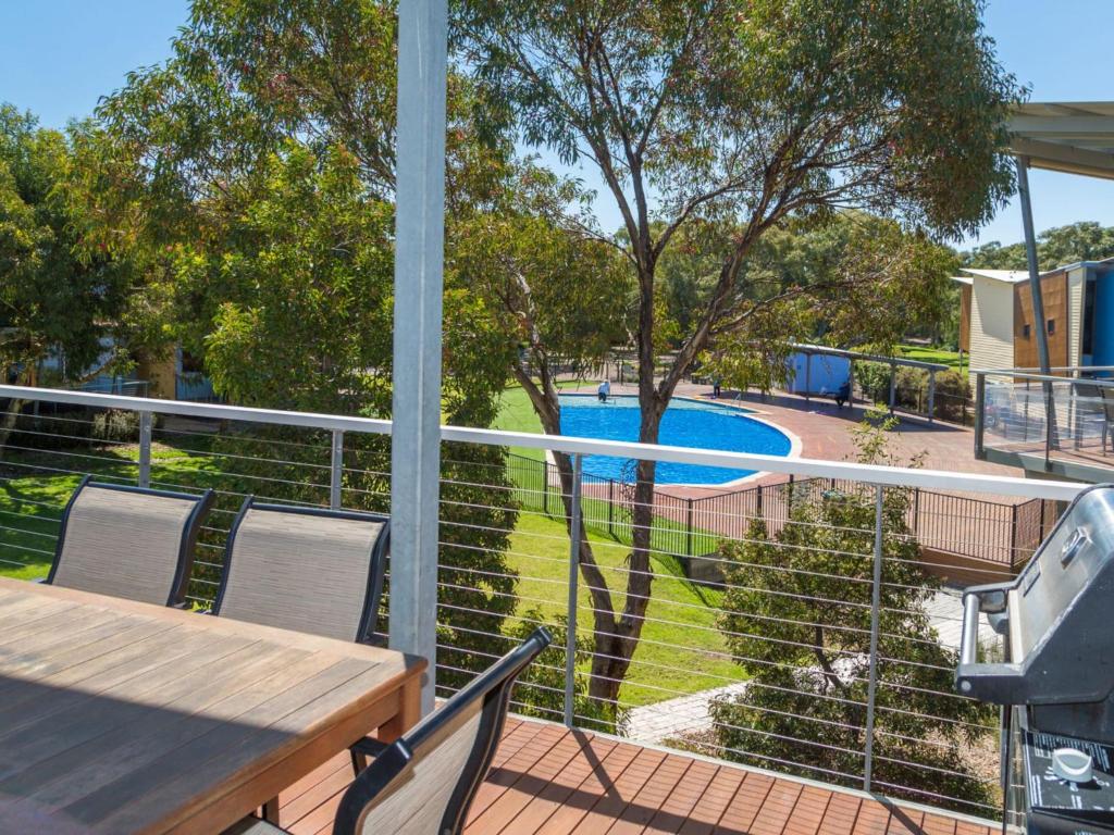 诺曼维尔South Shores Villa 52的一个带桌椅的阳台和一个游泳池