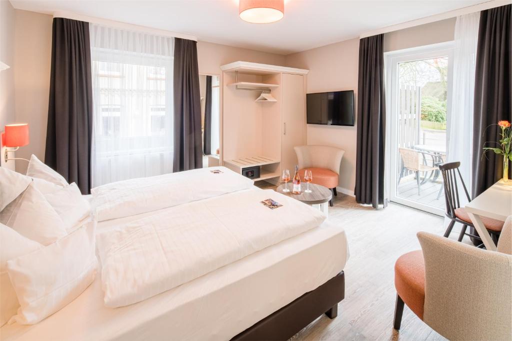 比斯平根Flair Hotel Rieckmann的酒店客房设有一张大床和一间客厅。