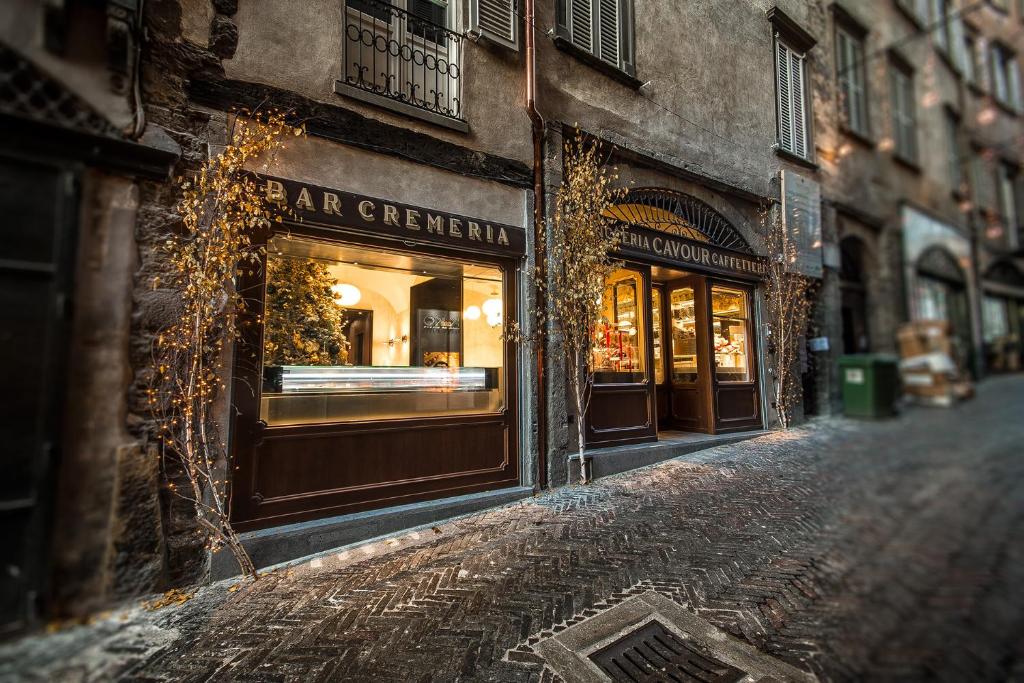 贝加莫Locanda Cavour的商店前有窗户的街道