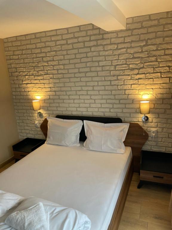 切尔诺莫雷茨Family Hotel Malibu的卧室配有白色的砖墙床