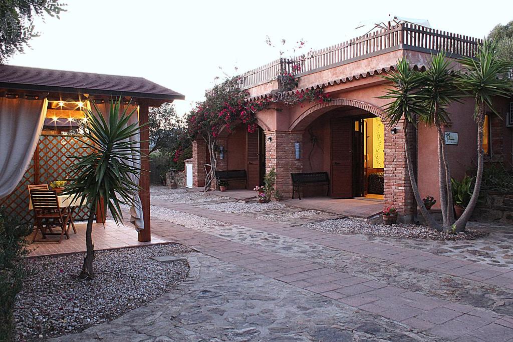 贡内萨Residenza Su Prelau的一座拥有拱形和棕榈树的房屋的庭院