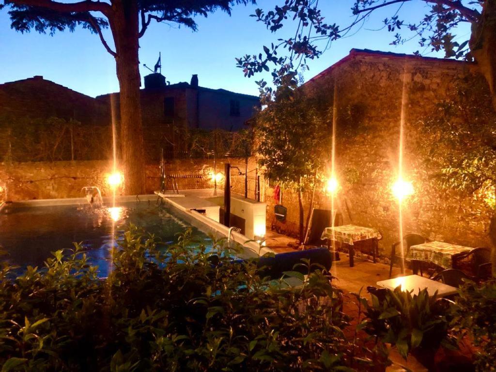 比博纳Locanda Etrusca的后院,晚上有游泳池,灯光照亮