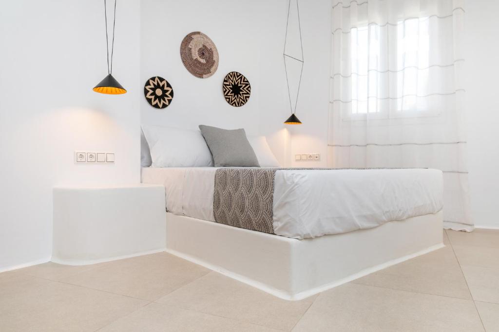 纳克索乔拉Naxos DownTown Apartments & Suites的白色的卧室,配有床和白色的墙壁