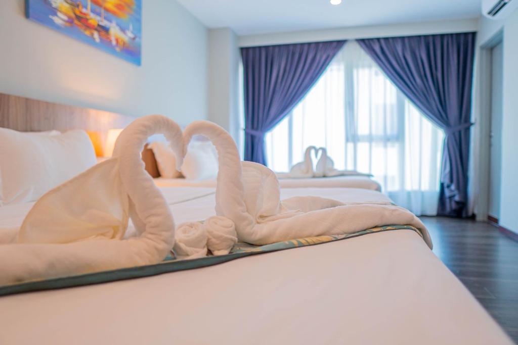 哥打京那巴鲁FLYPOD Hotel的床上用毛巾制成的两天鹅