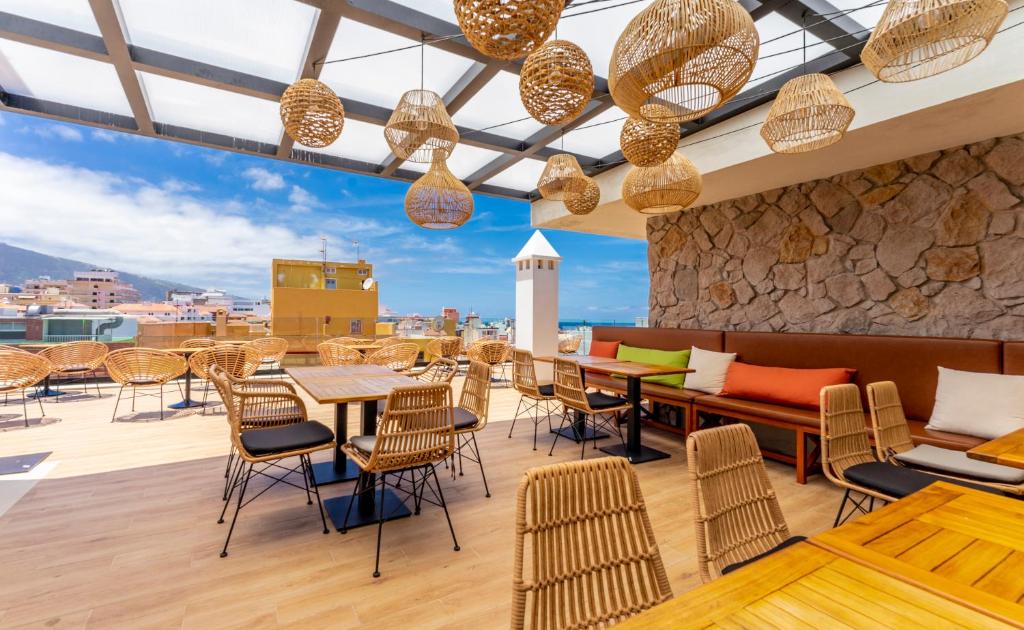 拉克鲁斯DWO Nopal的一间屋顶餐厅,配有桌椅,享有美景。