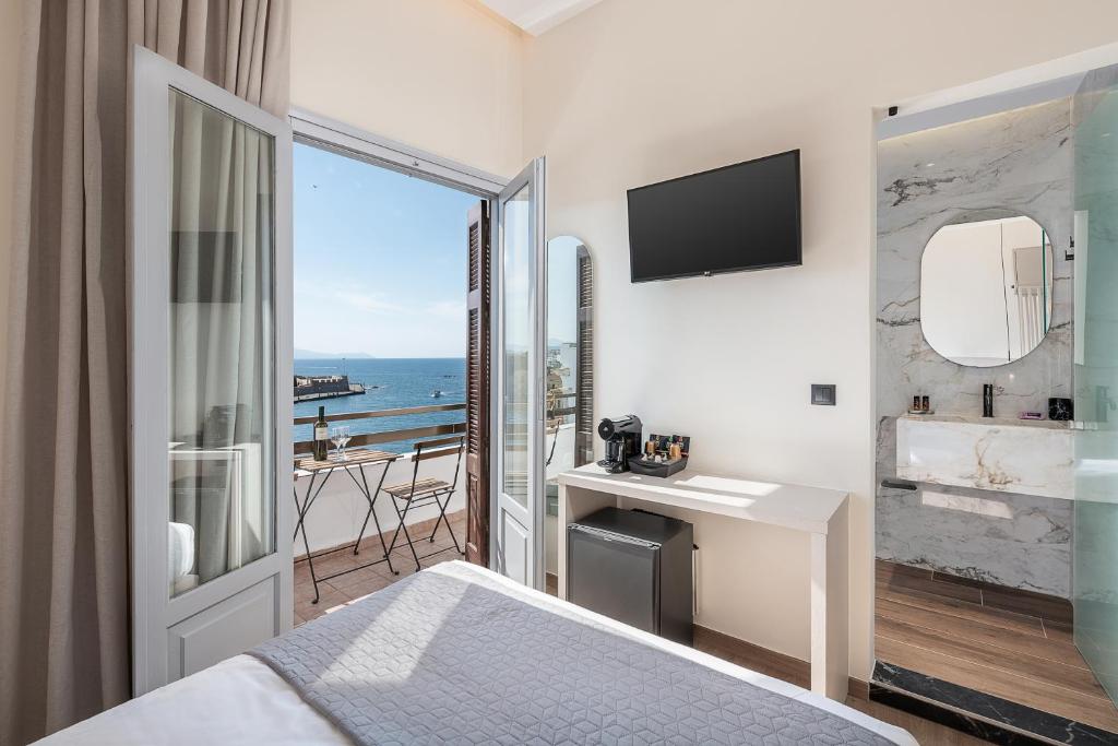 干尼亚Amphitrite Hotel的酒店客房设有一张床,享有海景。