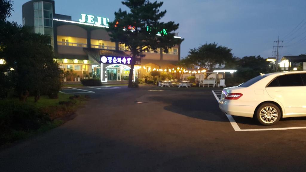 济州市济州印象旅馆的停在大楼前停车场的白色汽车