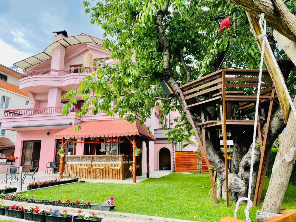 斯特鲁加Villa Cherry的前面有一棵树的粉红色房子