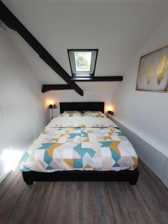 鲁昂Lodge de la Gare Vue Cathédrale的一间卧室配有一张带五颜六色被子的床