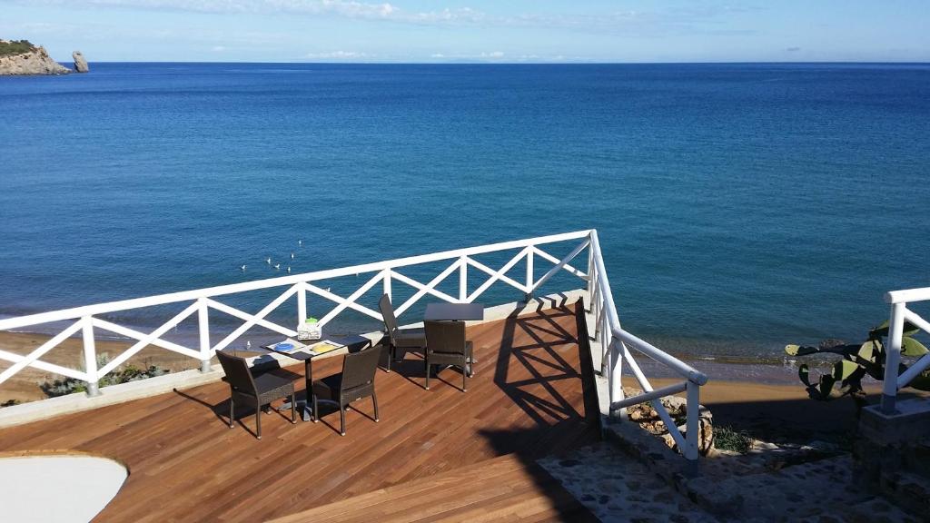 康培斯Le poste di Simplicio的阳台配有桌椅,俯瞰着大海