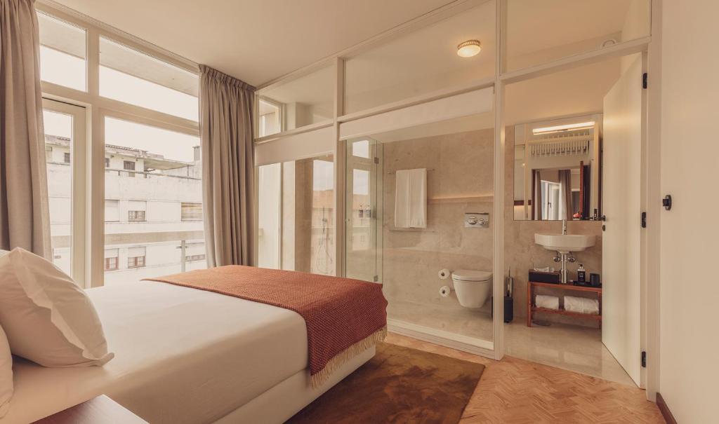波尔图Ceuta Terrace Suites的一间带白色大床的卧室和一间浴室