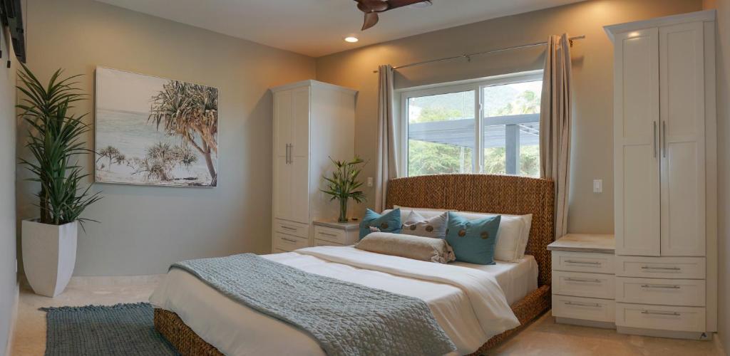OttleyʼsSunset Reef St. Kitts的一间卧室设有一张大床和一个窗户。