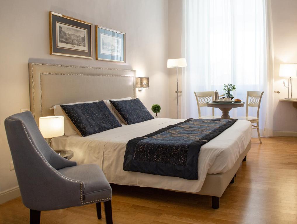 佛罗伦萨Boutique Hotel del Corso的一间卧室配有一张大床和一把椅子