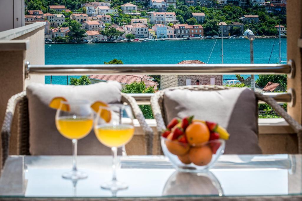 默克斯卡Apartments Du Lux的一张桌子,上面放着两杯葡萄酒和一碗水果