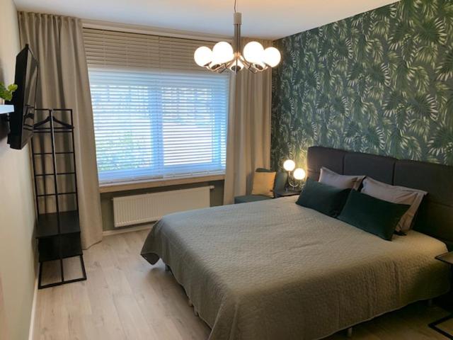 梅赫伦BnB De Koepoort的一间卧室设有一张大床和一个窗户。