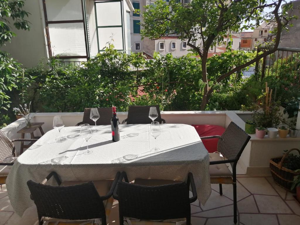 伯德古拉Apartmani Lucija的庭院里配有桌椅和一瓶葡萄酒