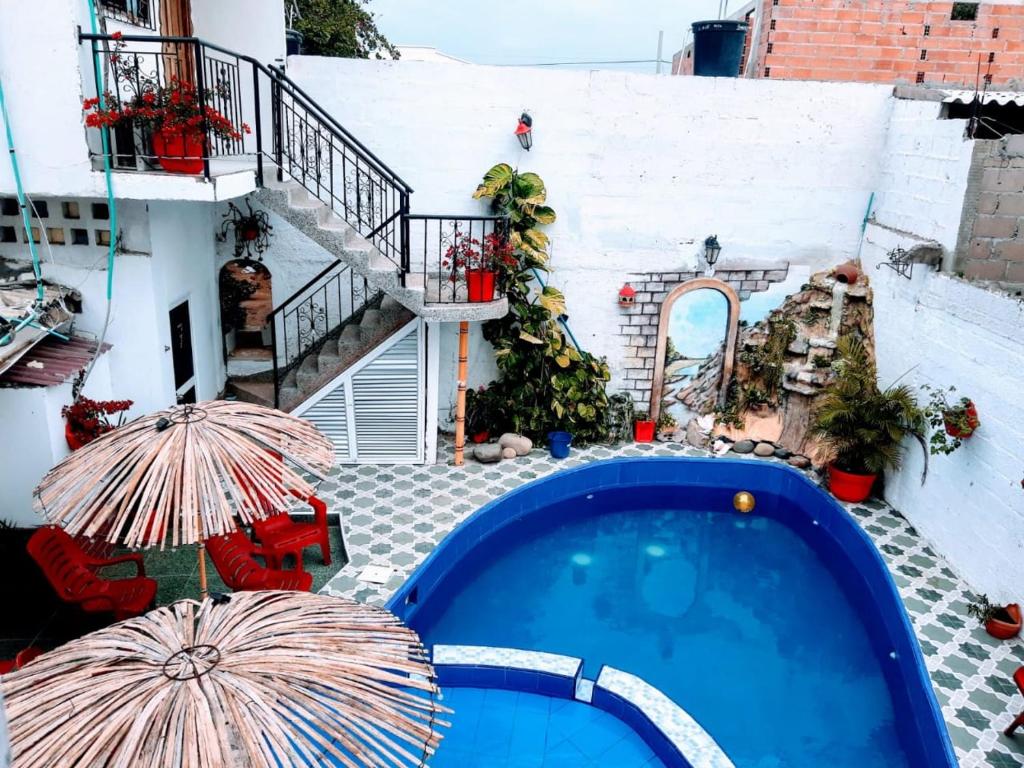 里奥阿查Hostal Solsticio Guajiro的一座游泳池,旁边设有两把遮阳伞