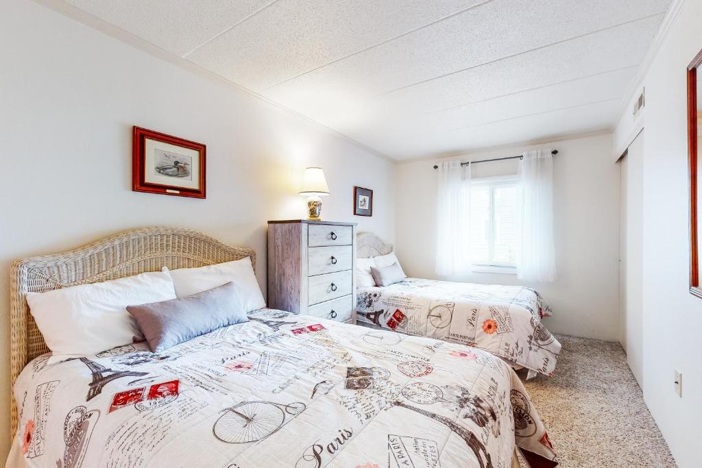 大洋城Assateague House II的一间卧室设有两张床和窗户。