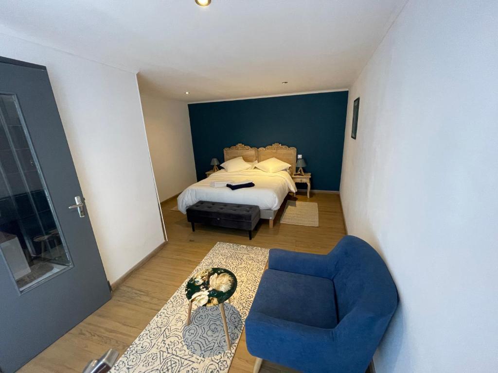 特雷布La pause du canal的一间卧室配有一张床和一张蓝色椅子