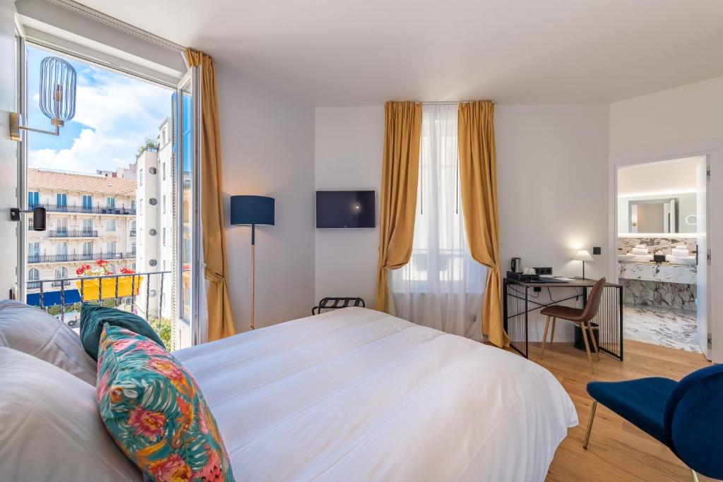 尼斯Boutique Hotel Nice Côte d'azur的一间卧室设有一张床和一个大窗户