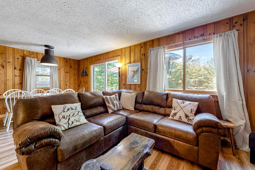 康威Rockhouse Mountain Retreat的客厅配有棕色皮沙发和桌子