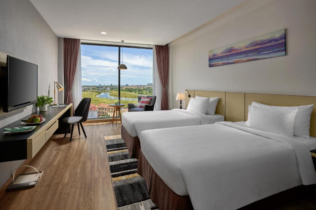 洞海Khách sạn SAM Quảng Bình的酒店客房配有两张床和一张书桌