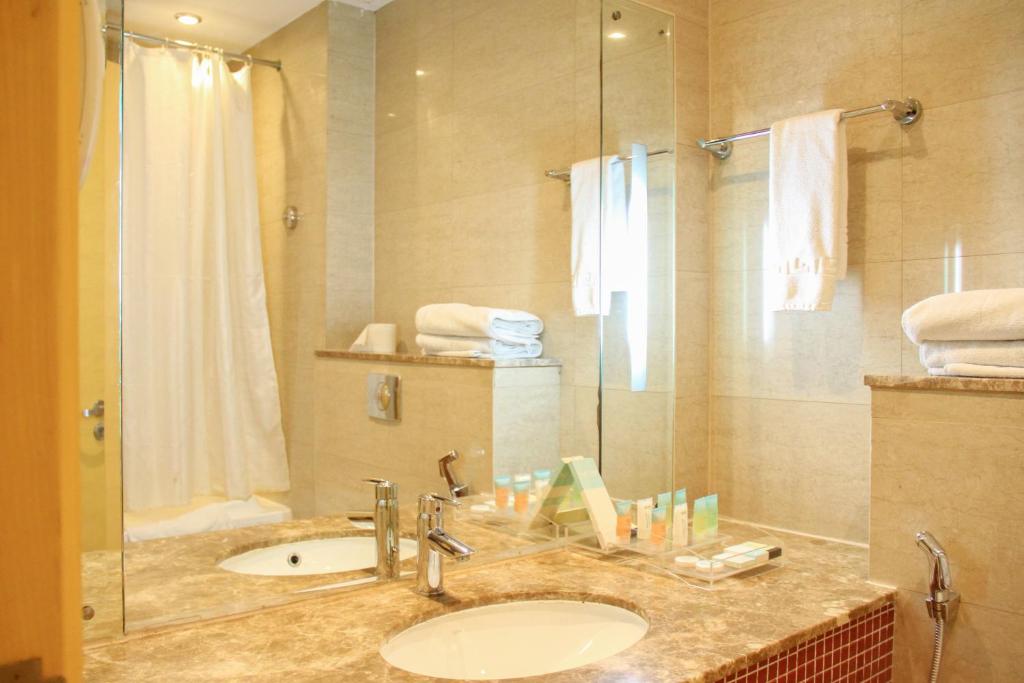 迪拜The Leela Hotel的一间带水槽和淋浴的浴室