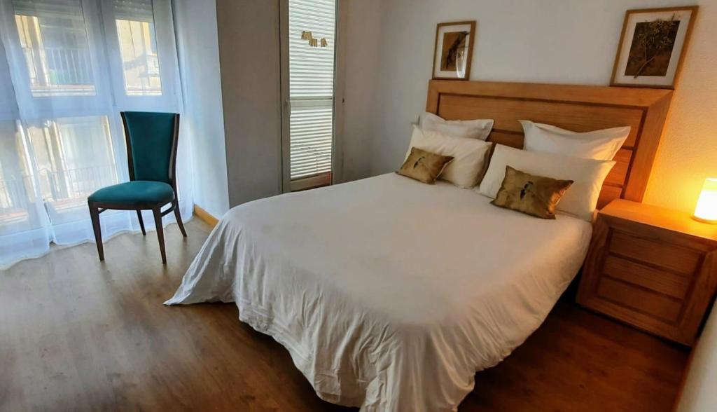 桑坦德Apartamento en Reina Victoria的卧室配有白色的床和椅子