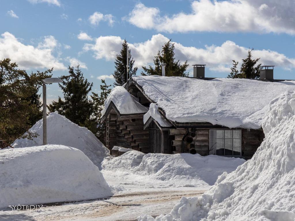 索特Revontuli 6的雪覆盖在道路旁的小木屋
