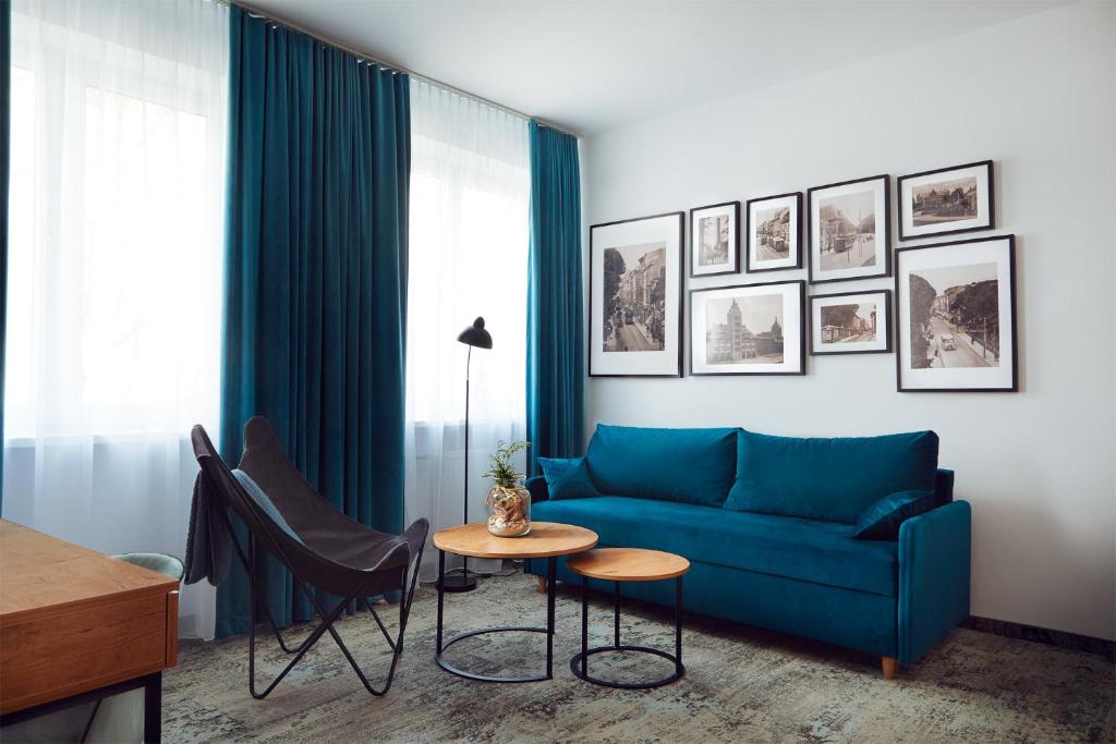 科沙林Stary Koszalin Hostel &amp; Hotel Services的客厅里有一张蓝色的沙发和一张桌子